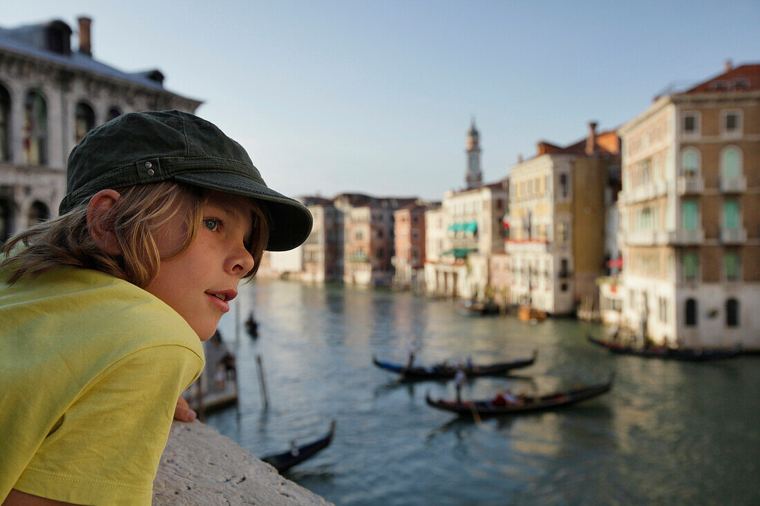 Child looking from the Rialto bridge towards Canale Grande, Venice, Veneto, Italy
