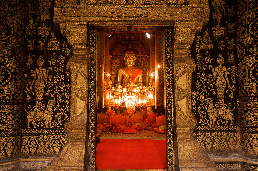 Buddhist monks at evening prayer, Wat Xieng Thong, Luang Prabang, Laos