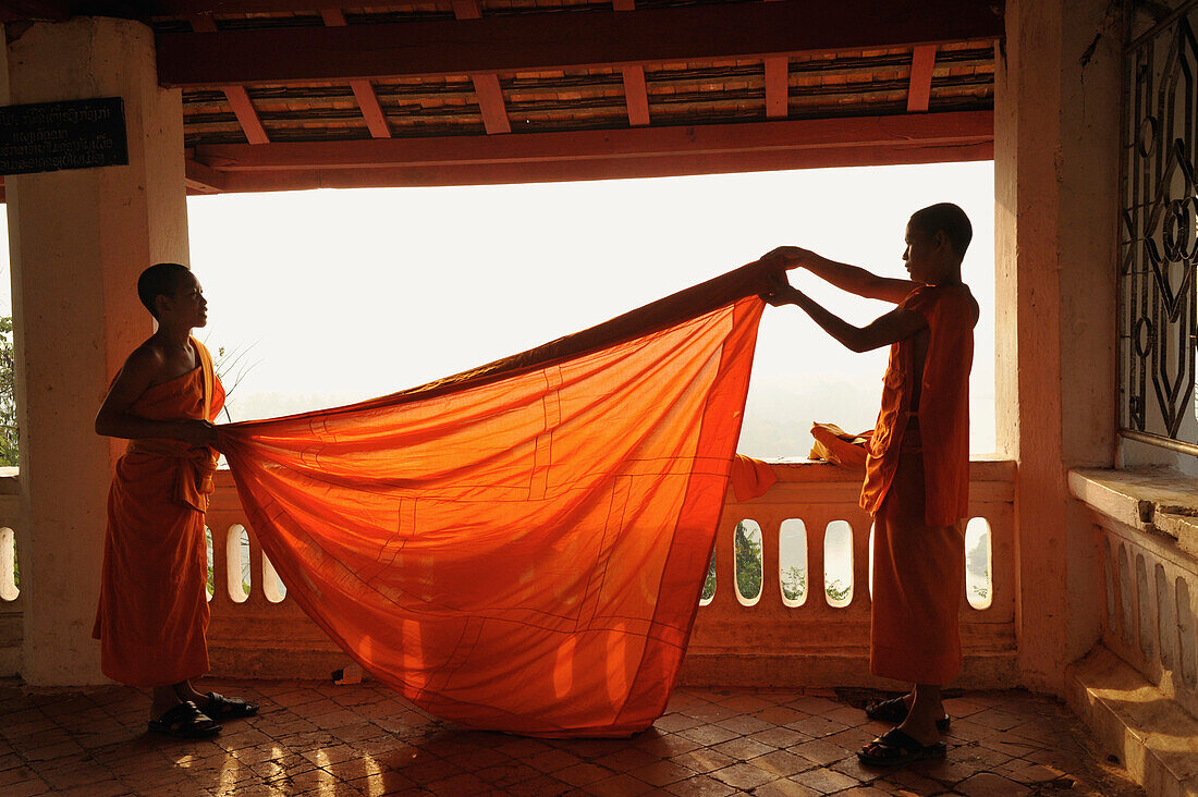 Junge Mönche, Novizen, legen ihre Robe zusammen, Phu Si Hügel, Luang Prabang, Laos, Südostasien, Asien