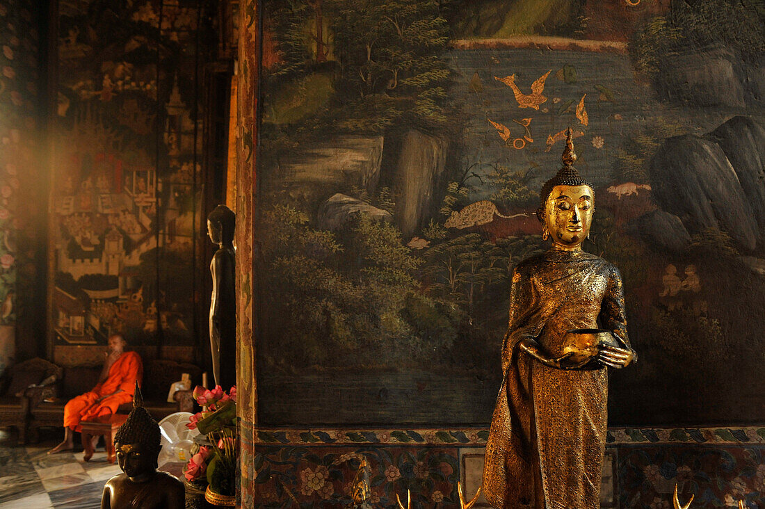 Buddha statue and monk in teh background, Wat Suthat, Bangkok, Thailand, Asia