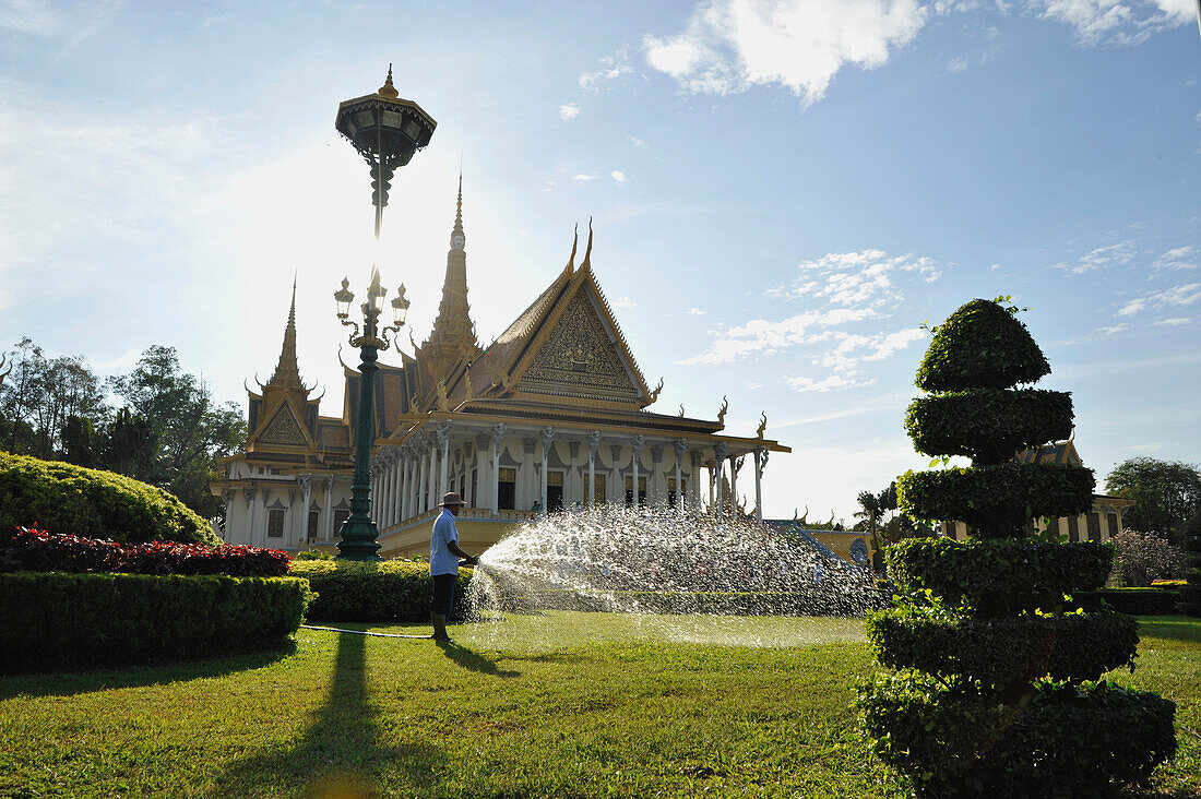 Garden with gardener pouring the grass, Royal Palace, Phnom Penh, Cambodia