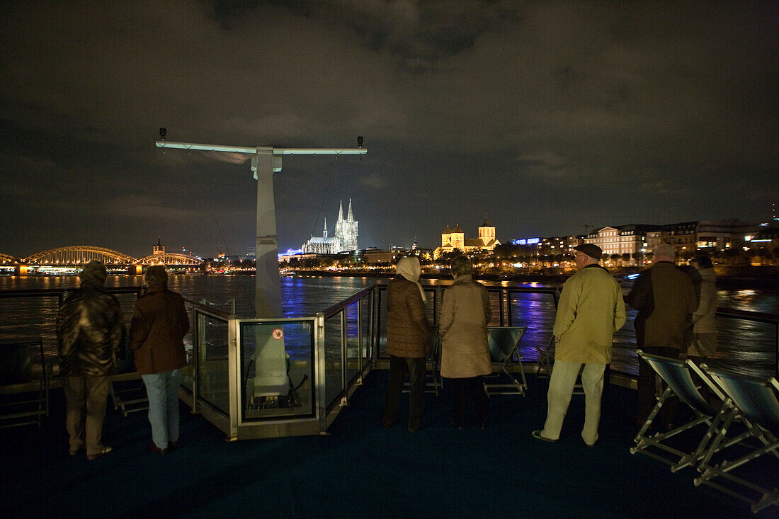 Gäste an Bord von Flusskreuzfahrtschiff MS Bellevue, TransOcean Kreuzfahrten, blicken auf den Kölner Dom bei Nacht, Flusskreuzfahrt auf dem Rhein, Köln, Nordrhein-Westfalen, Deutschland