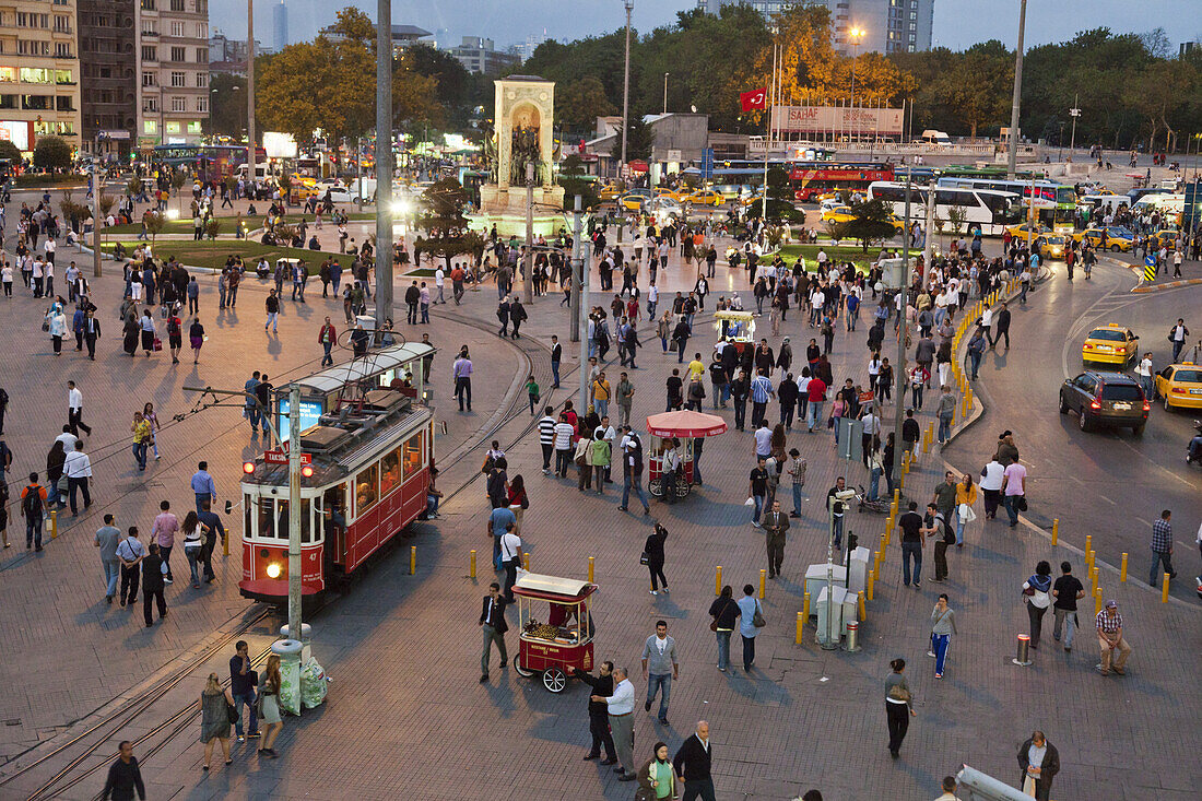 People and tram at Taksin square in the evening, Cumhuriyet Abidesi monument, Istanbul, Turkey, Europe