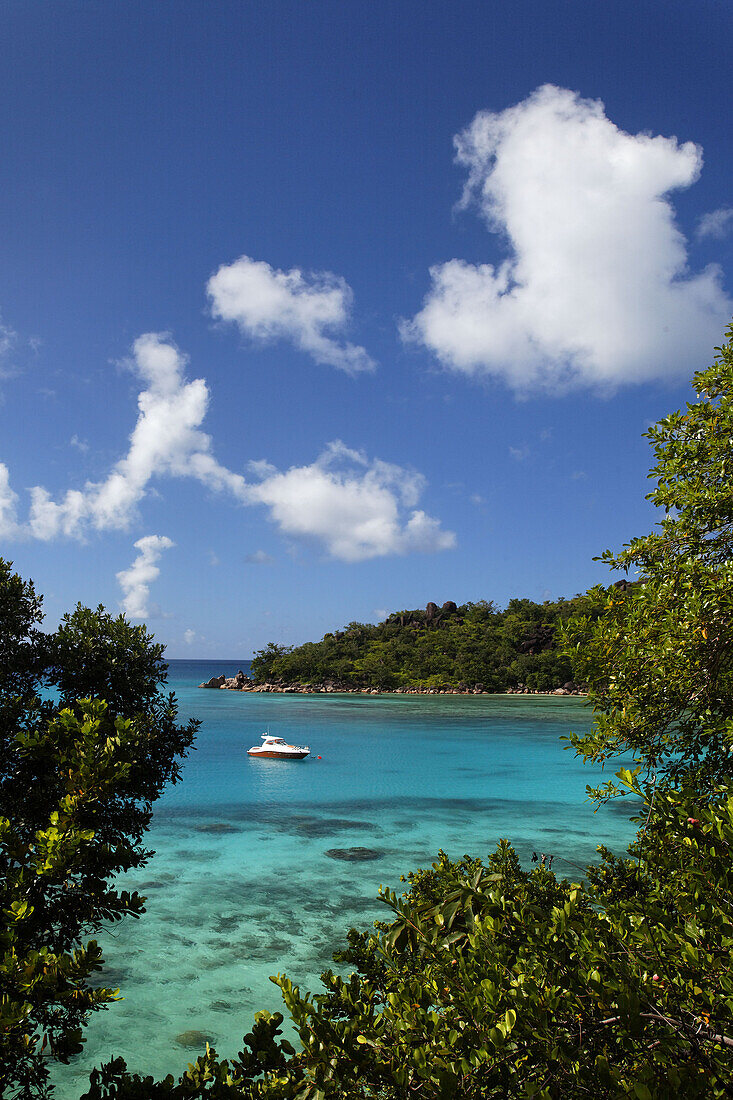 Boot in einer Bucht im Sonnenlicht, Baie Ste Anne, Anse Petit Cour, Praslin, Seychellen, Indischer Ozean