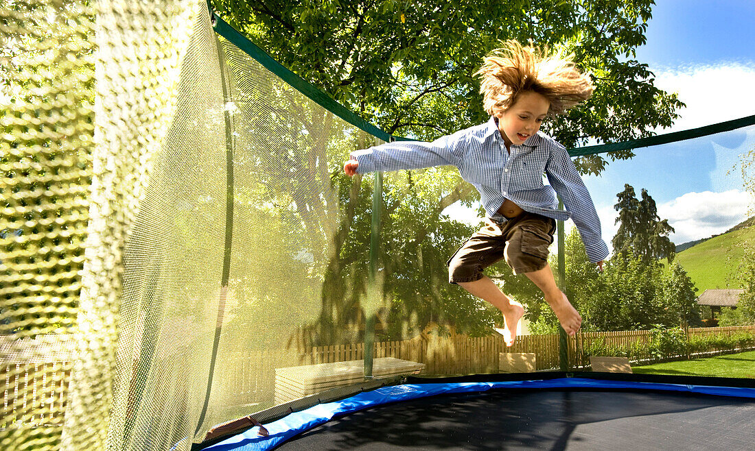 Boy jumping on a trampoline, South Tyrol, Italy, Europe