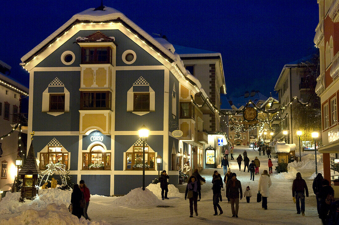 Menschen auf verschneiter Strasse am Abend, St. Ulrich, Gröden, Südtirol, Italien, Europa