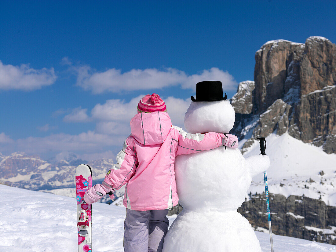 Kleines Mädchen mit Ski und Schneemann, Alto Adige, Südtirol, Italien, Europa