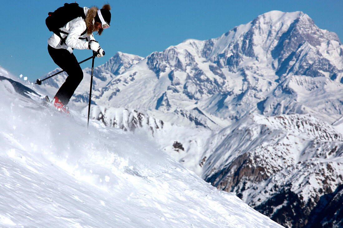France, Alps, Savoie, Courchevel 1850, female skier in action, Mont Blanc in background