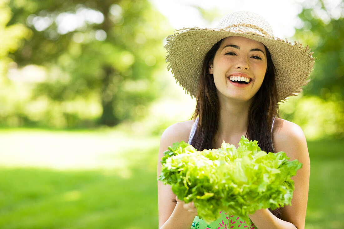 Young woman holding a lettuce