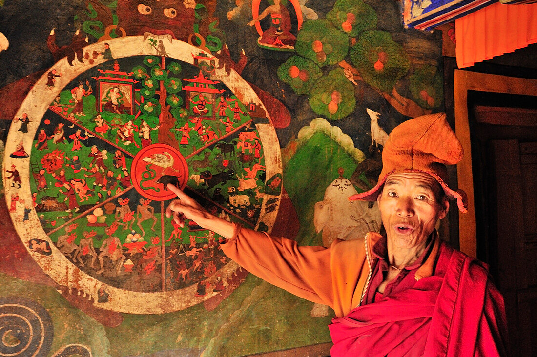 Yellow-hat monk explaining wheel of life, monastery of Lingshed, Lingshed, Zanskar Range Traverse, Zanskar Range, Zanskar, Ladakh, India