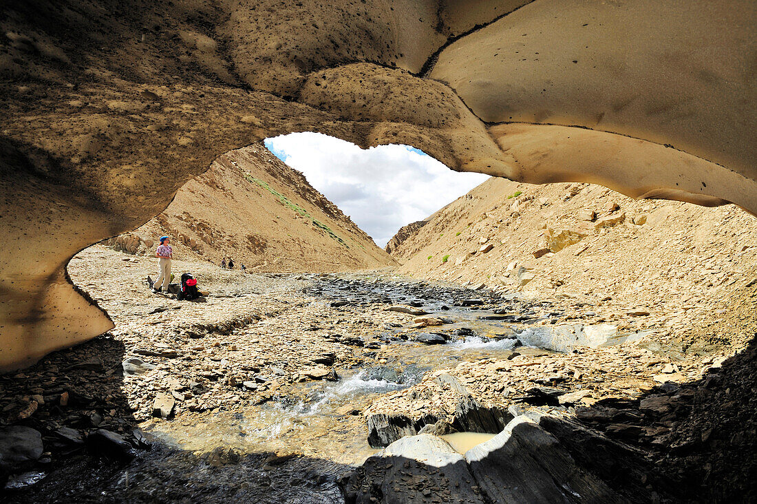 View out of a snow-cave to a resting woman, Hanuma La, Lingshed, Zanskar Range Traverse, Zanskar Range, Zanskar, Ladakh, Jammu and Kashmir, India