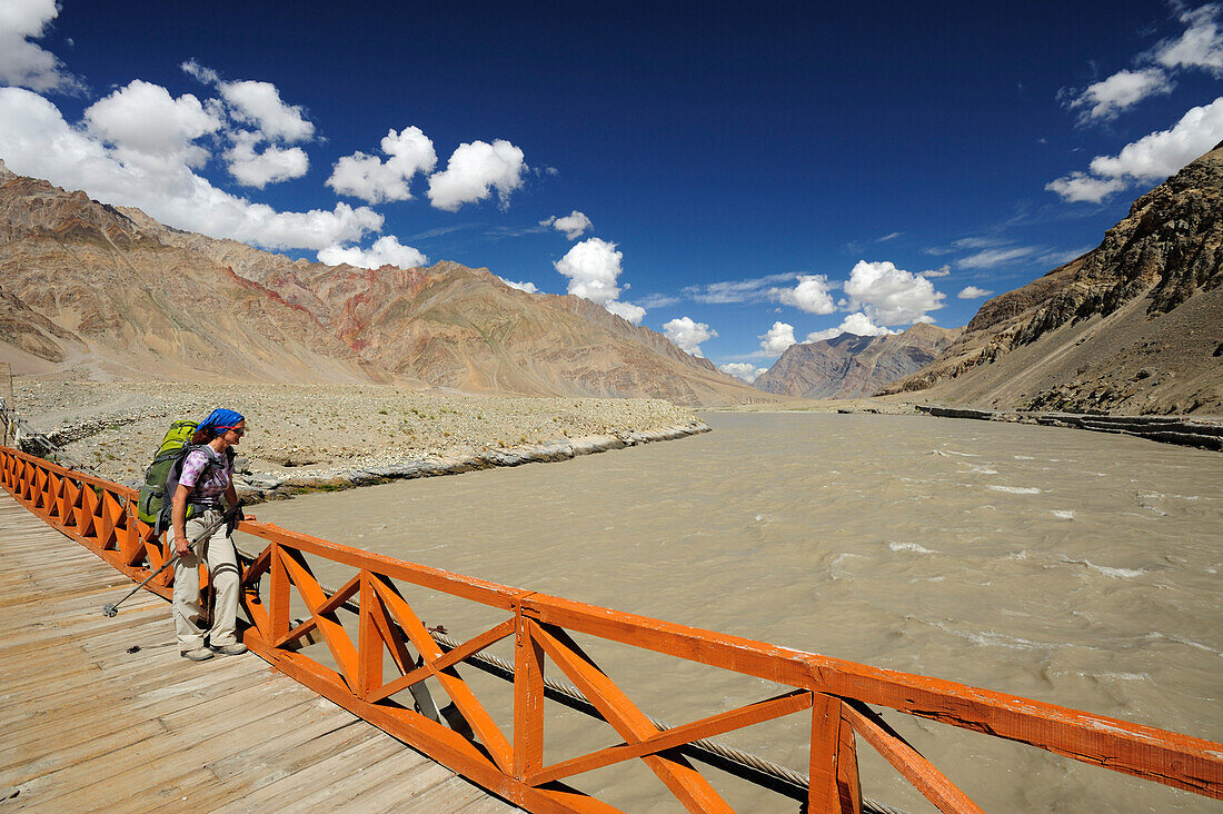 Frau überquert Zanskar River auf einer Hängebrücke, Zangla, Großer Zanskar Trek, Zanskargebirge, Zanskar, Ladakh, Jammu und Kashmir, Indien