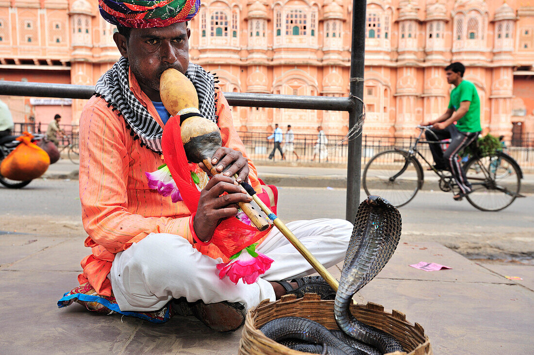 Snake charmer with palace of winds in background, palace of winds, Hawa Mahal, Jaipur, Rajasthan, India