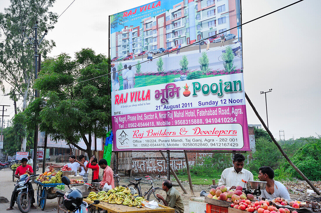 Marktstände mit Obst und Werbung für Neubau einer Wohungsanlage, Agra, Uttar Pradesh, Indien