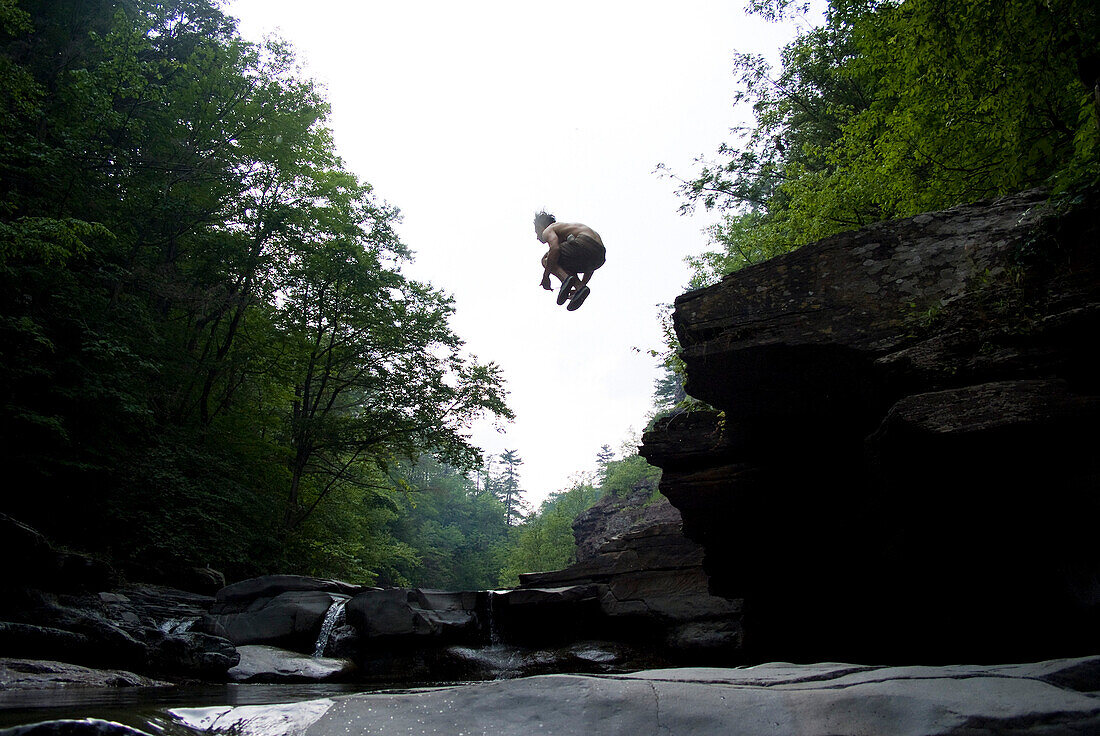 Young Man Jumping into Water, Low Angle View