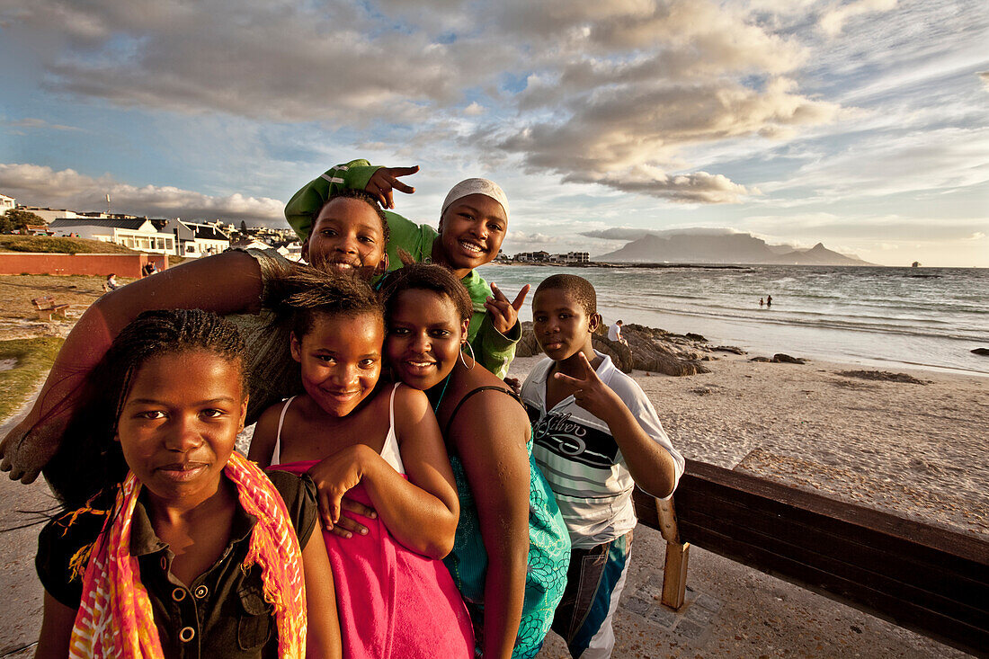 Beach impression with young coloured teenagers at Bloubergstrand, Cape Town, Western Cape, South Africa, RSA, Africa