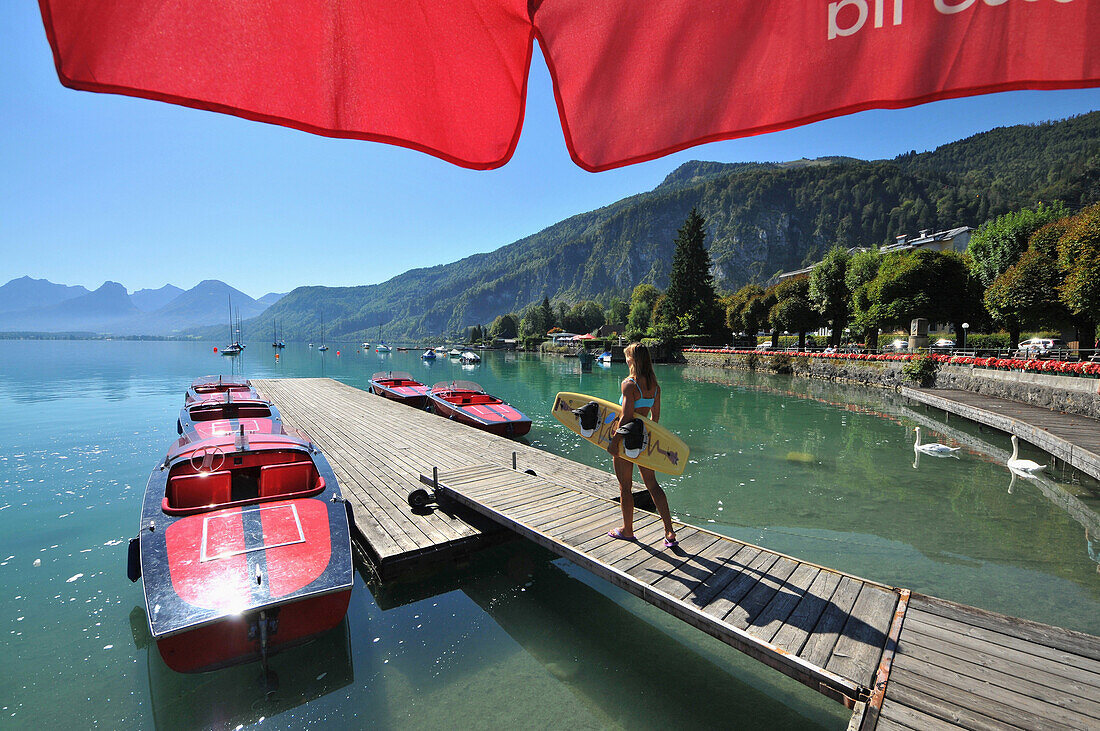 aFrau am Holzsteg am See von St. Gilgen am Wolfgangsee, Salzkammergut, Salzburg, Oberösterreich, Österreich