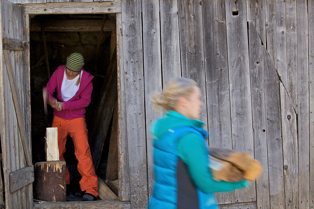 Young women chopping firewood, See, Tyrol, Austria