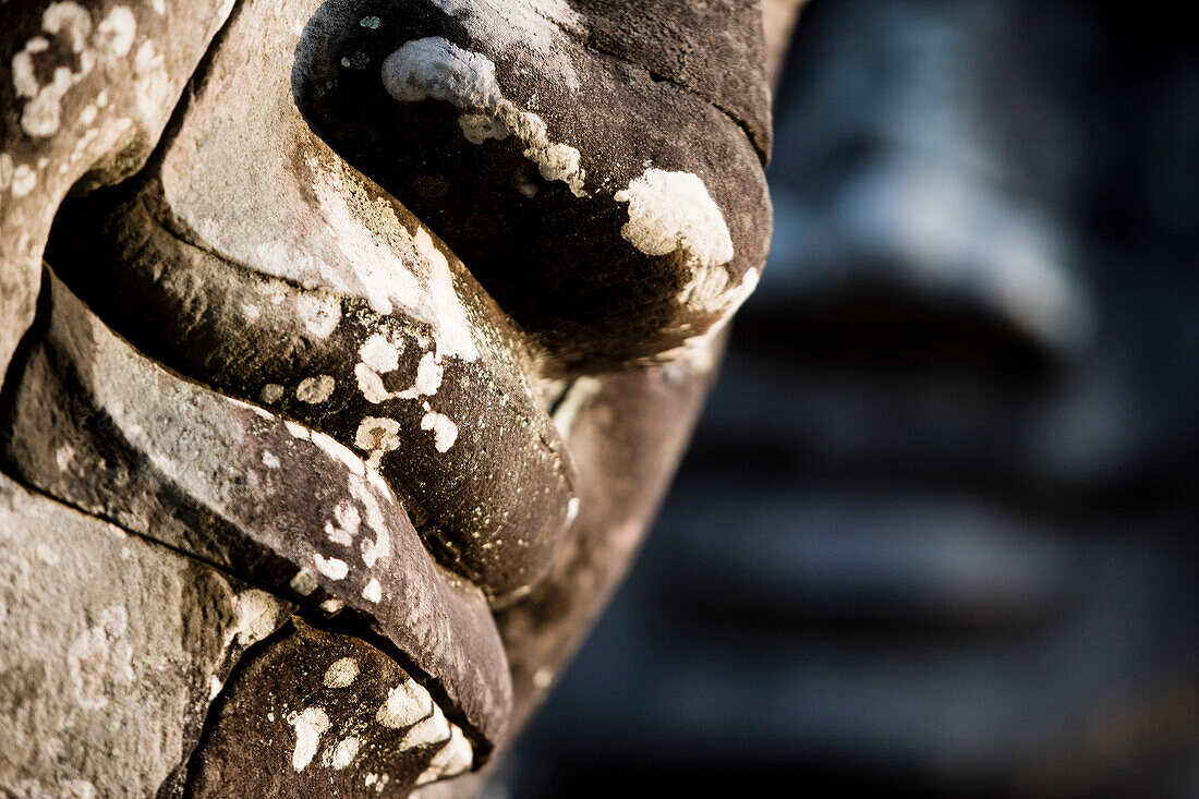 Detail of some of the  216 giant faces of Avalokiteshvara, Giant stone faces watch over visitors in the temple of Bayon. Temples of Angkor, Siem Reap, Cambodia.