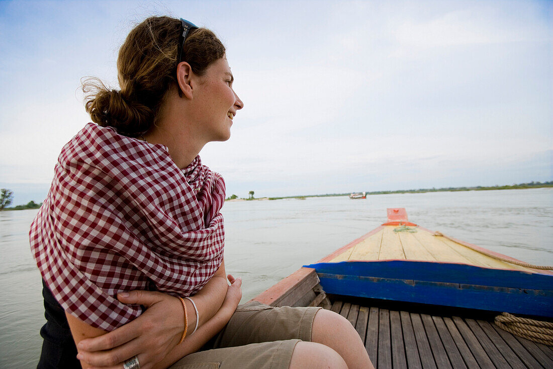 Tourist looking for Irrawaddy dolphins during a boat trip, Mekong river at Kampi village near to Kratie, Cambodia.