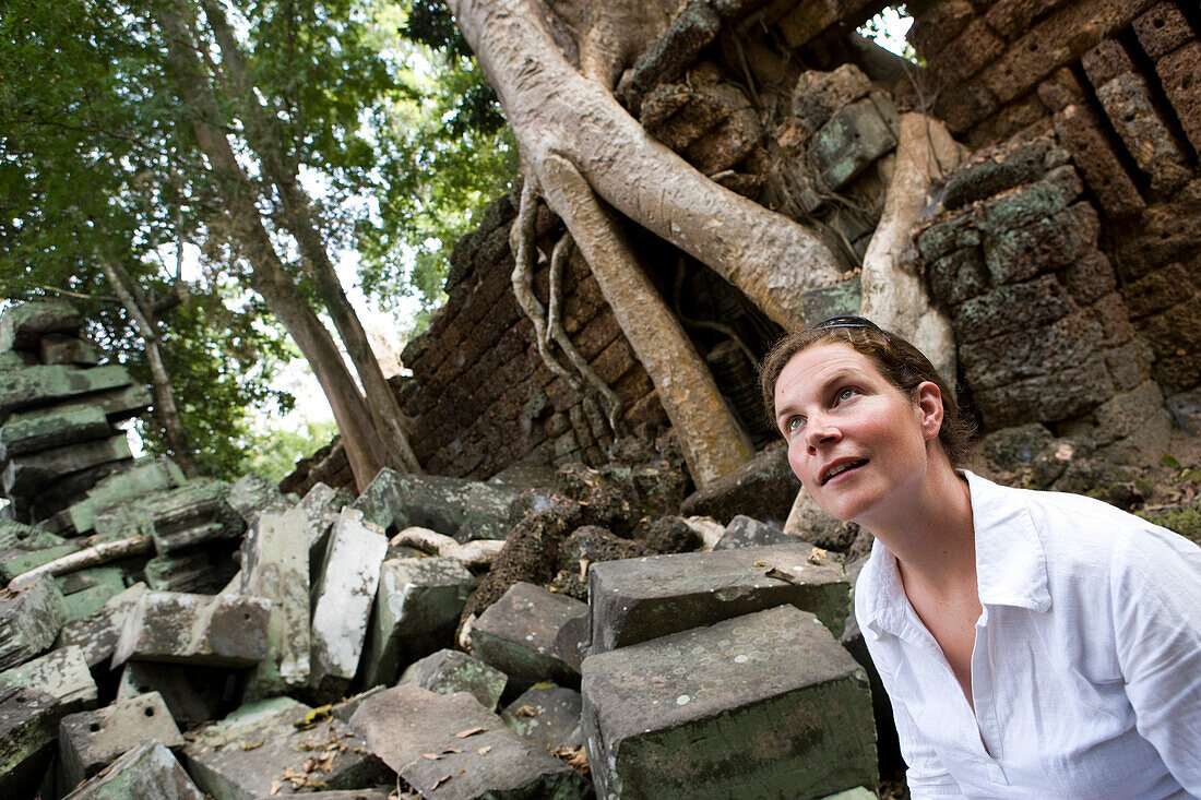 Tourist sightseeing inside temple, Temple of Ta Prohm, Angkor Wat, Siem Reap, Cambodia.