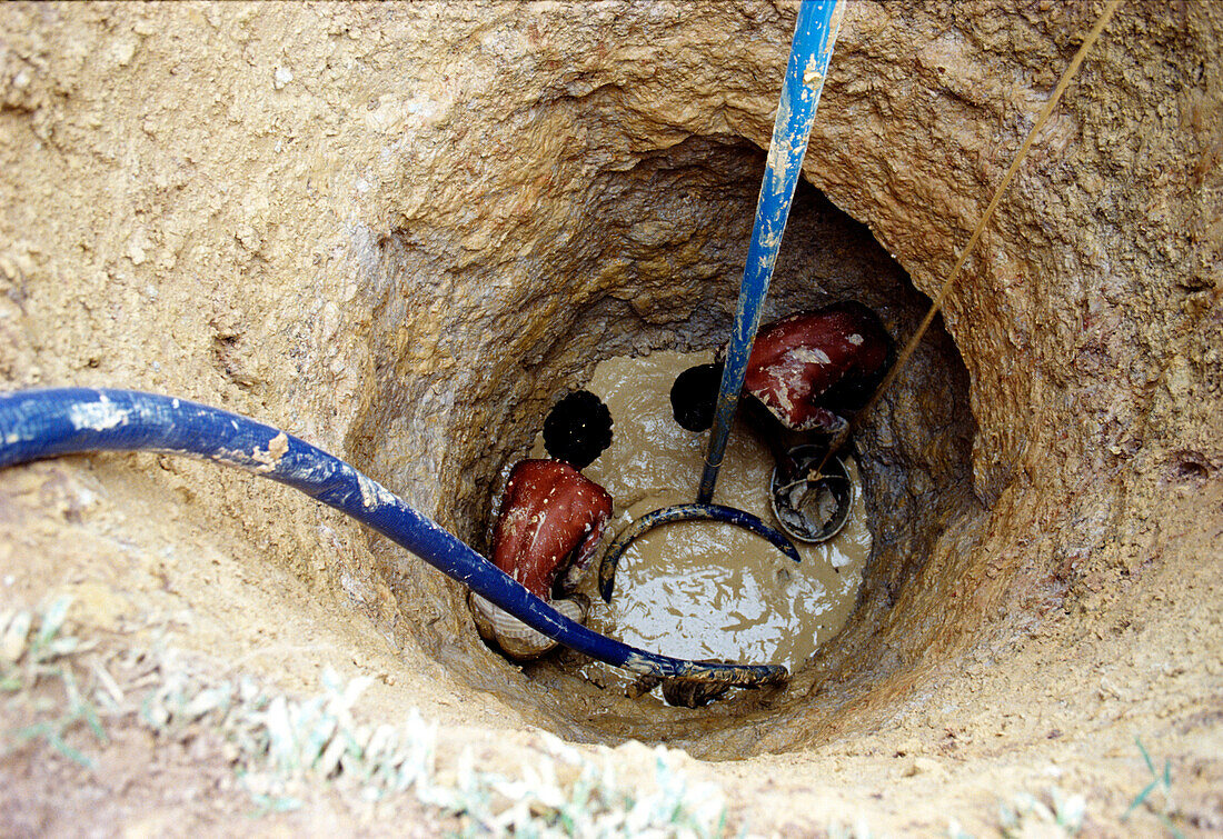 Two men digging a well, Cambodia