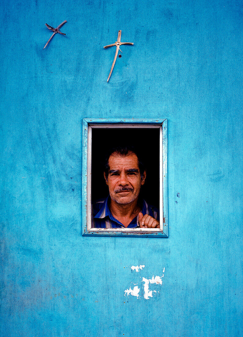 Portrait of man looking through window, Costa Rica
