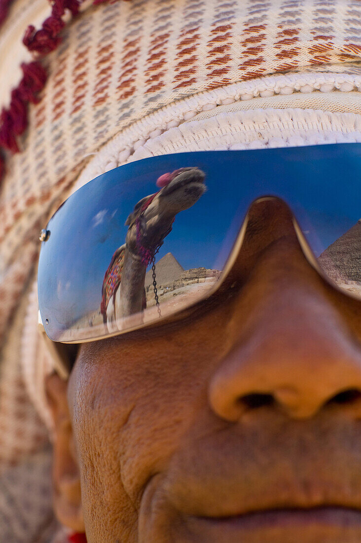 Reflection of camel in man's sunglasses, NULL