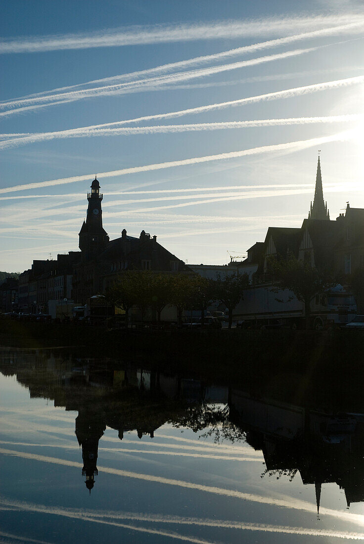 Airplane contrails above the town of Chateaulin early in the morning, Brittany, France
