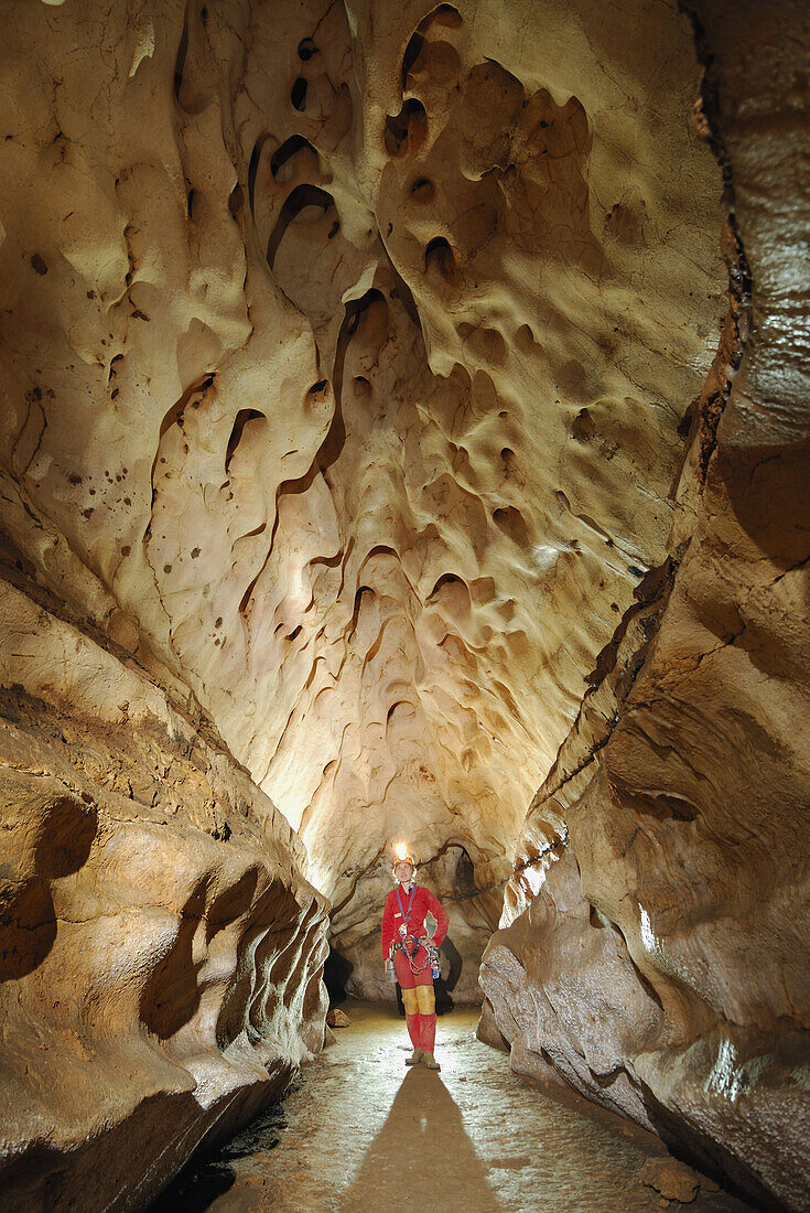 Speleology, caving, caver in a gallery, Gard (France)