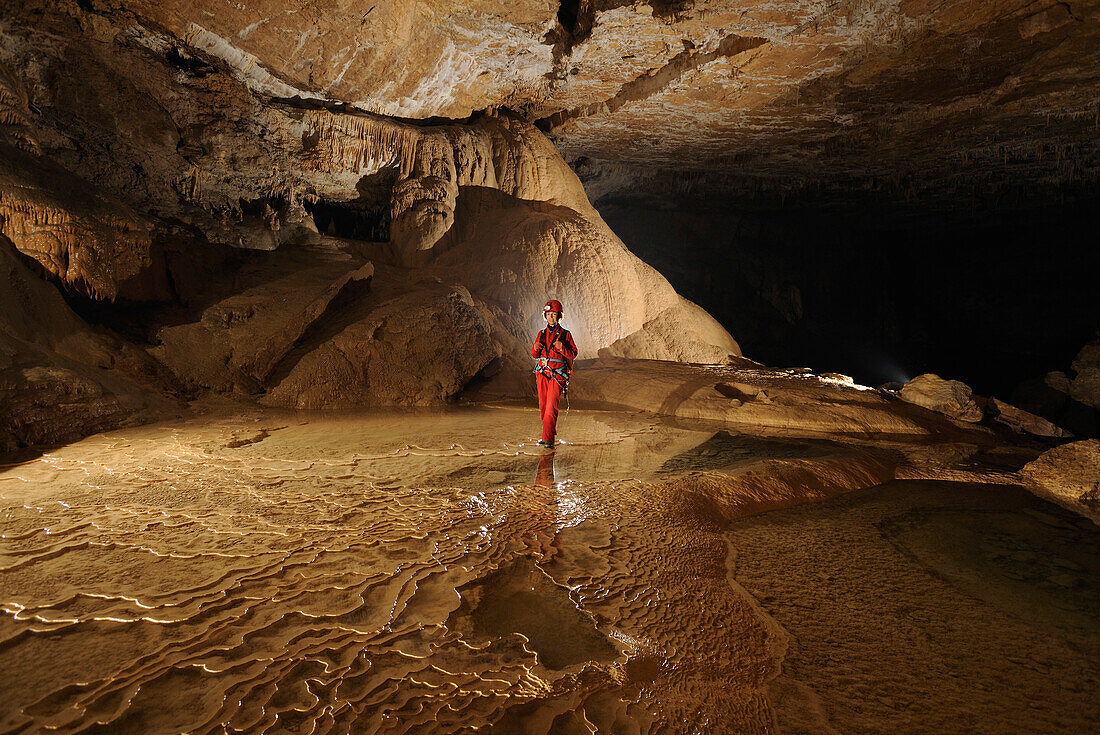 Speleology, caving, caver in a gallery with rimstone pools , Grotte de Gournier (Isere,  France)