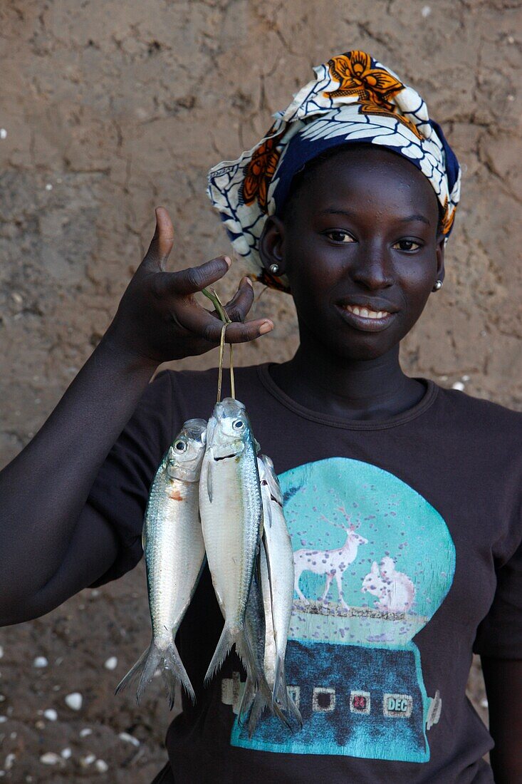 Sénégal, Kafountine, Woman holding fish