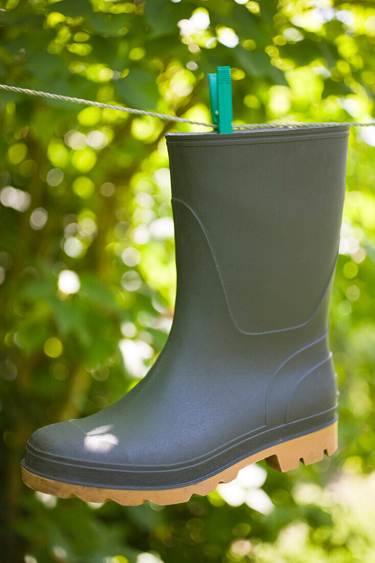 Rubber boot suspended in a thread in garden