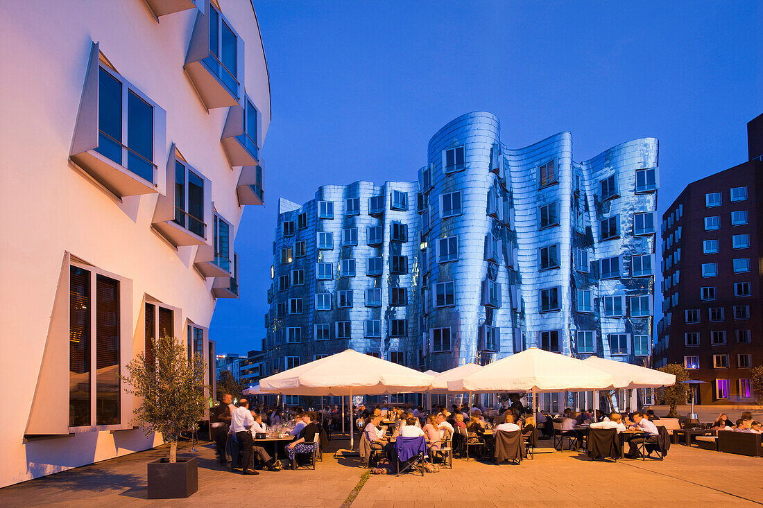 Restaurant terrace and  buildings in the evening, Neuer Zollhof, Media harbour, Duesseldorf, Rhine river, North Rhine-Westphalia, Germany, Europe