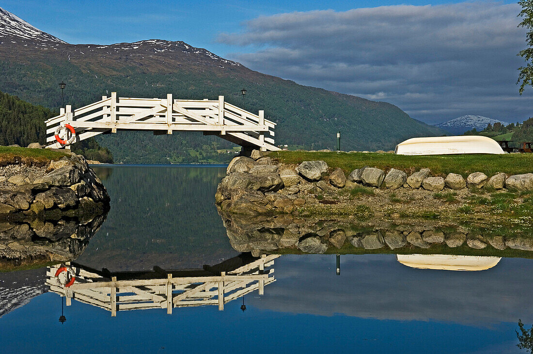 White footbridge over lake with reflections, Loen. Stryn. Nordfjord. Norway
