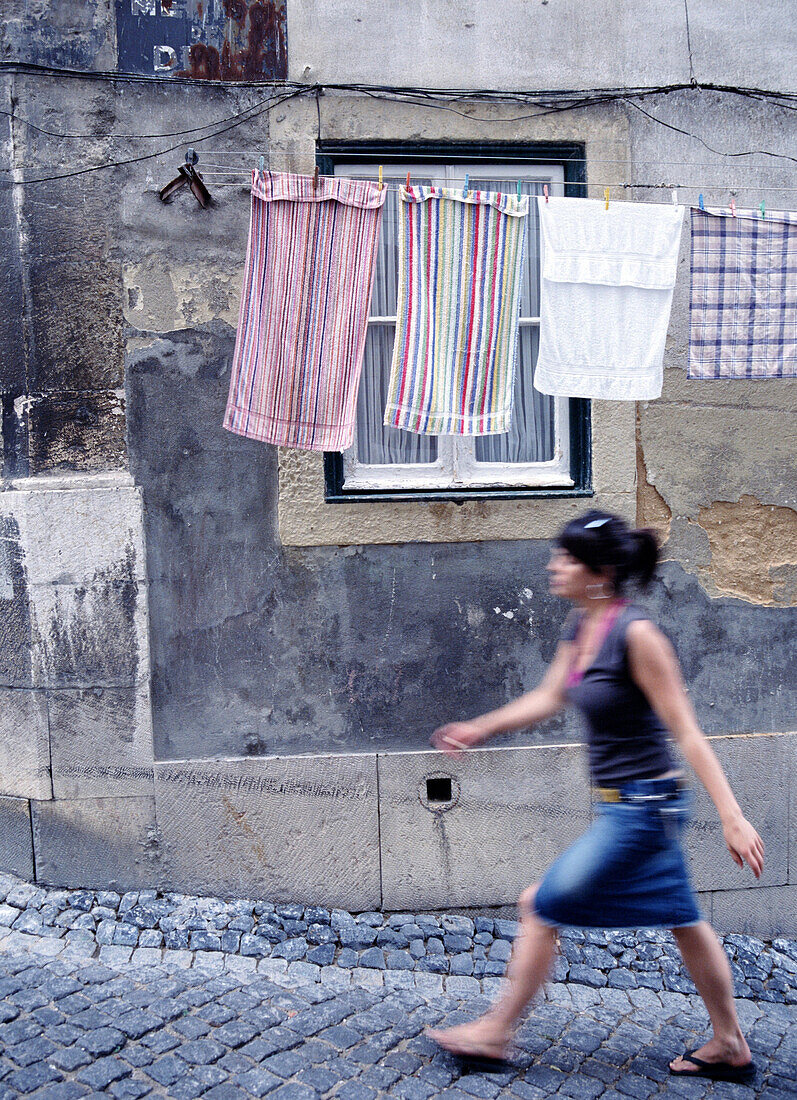 Woman walking by washing line, Alfama, Alfama, Lisbon, Portugal