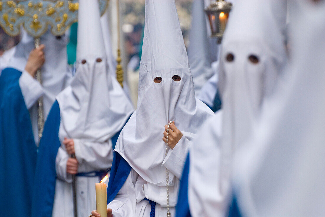 People wearing robes and masks with hoods at Santa Semana Easter festival, Cadiz, Andalucia, Spain