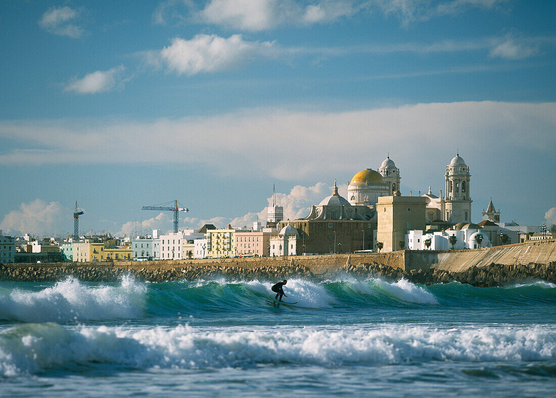 Surfer in front of Santa Cruz cathedral, Cadiz, Andalucia, Spain