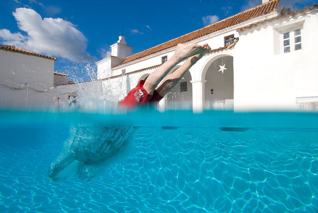 Man diving into swimming pool, split level, Andalusia, Spain