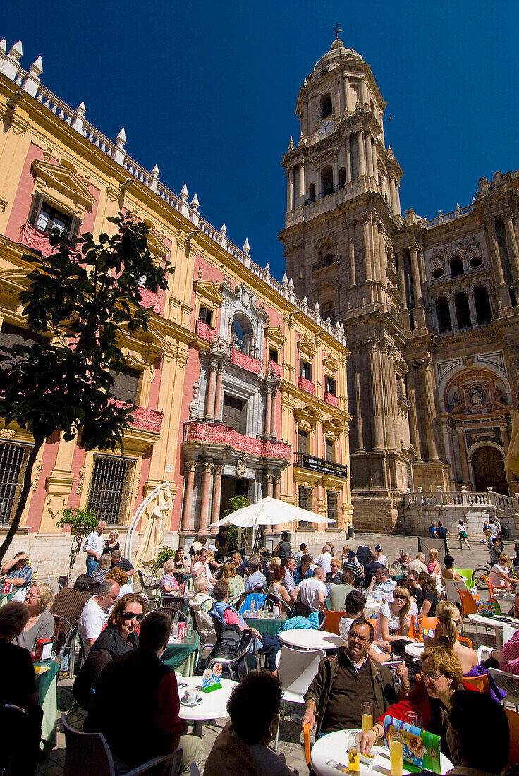 People at cafe tables in square in front of cathedral and Palacio Episcopal, Malaga, Andalucia, Spain