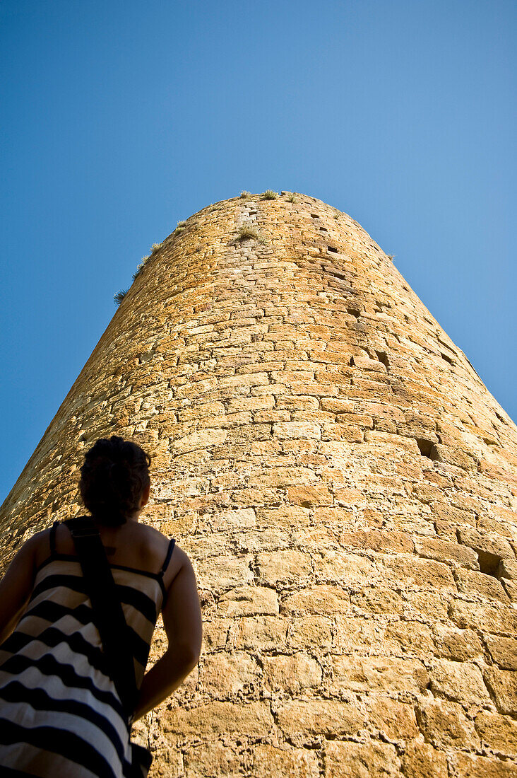 Girl looking at castle tower in medieval village, Pals, Costa Brava, Catalunya, Spain