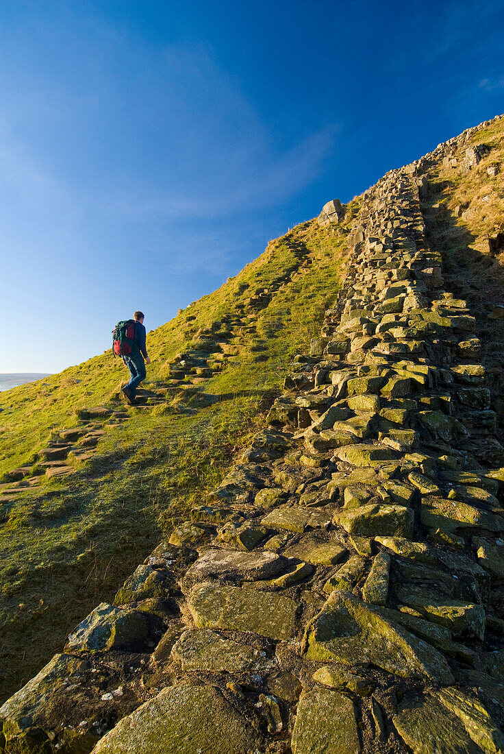 Man walking along Hadrian's Wall, Northumerland, England, UK