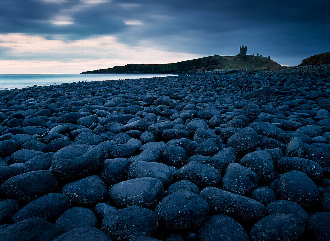 Embleton Bay and Dunstanburgh Castle in distance, night, Northumberland, England, UK