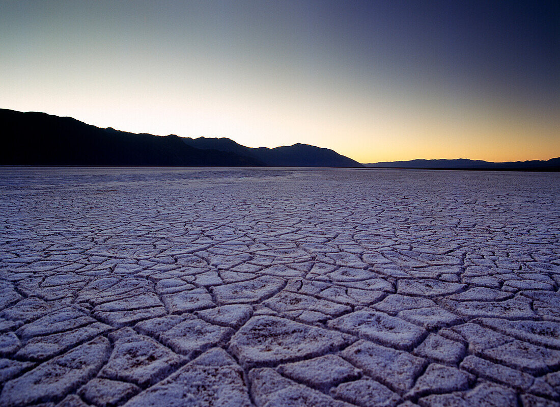 Looking across the purple saltpans at Badwater at dusk, Death Valley National Park, California