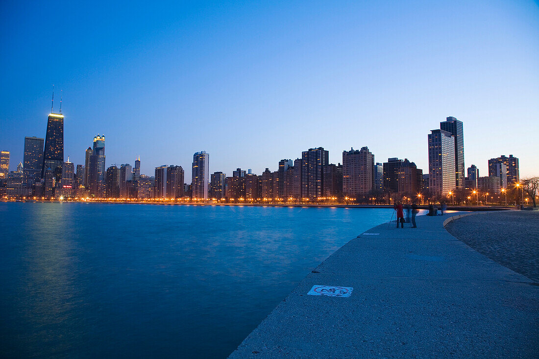 People photographing city skyline at dusk, Chicago, Illinois, USA