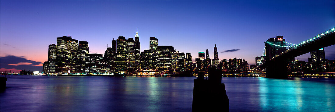 Lower Manhattan and Brooklyn Bridge illuminated at dusk, New York City, New York State, USA