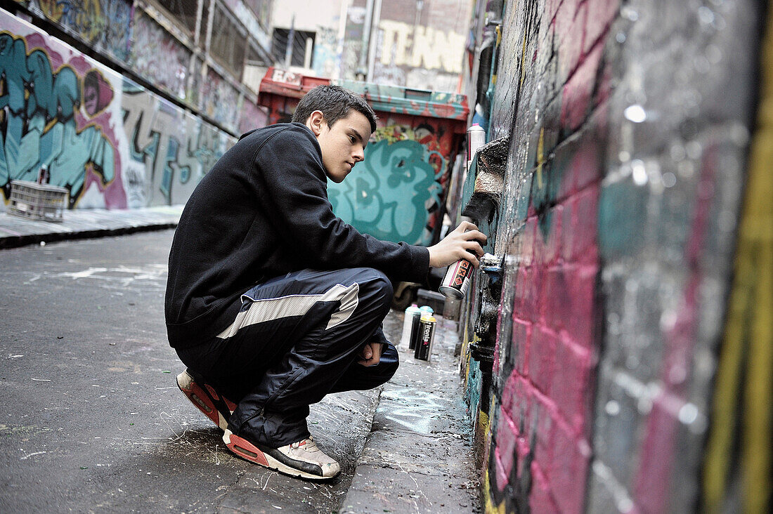 Junger Graffiti Künstler besprüht eine Hauswand, Sreet art, Melbourne, Vicoria, Australien