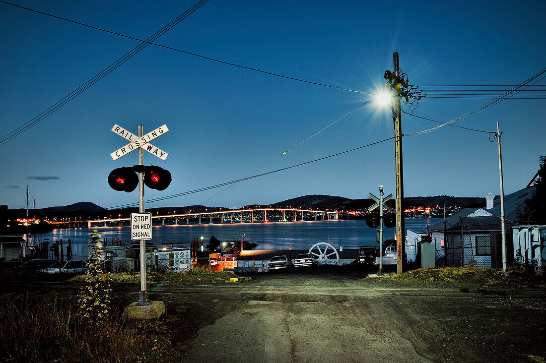 Rail crossing with view at Tasman bridge and Derwent River, Hobart, Australia