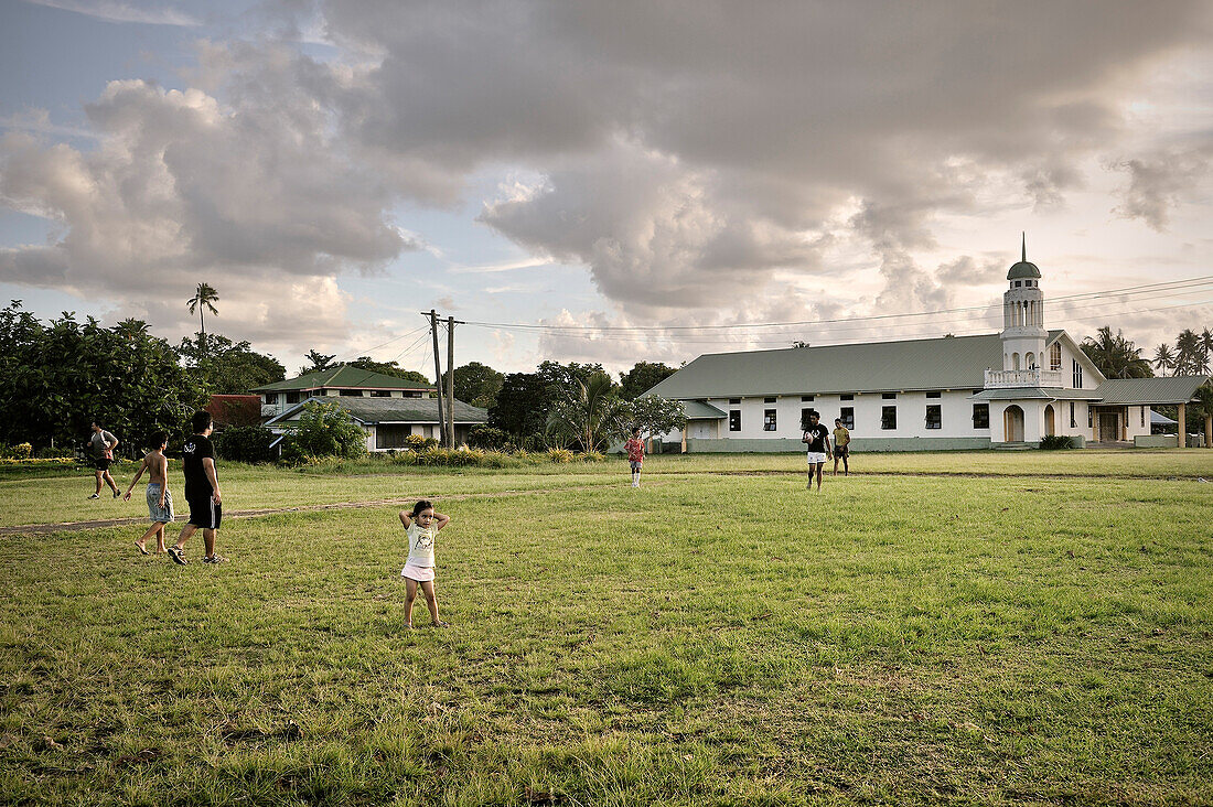 Locals play rugby in front of a church, typical village lifestyle, Apia, Upolu, Samoa, Southern Pacific island