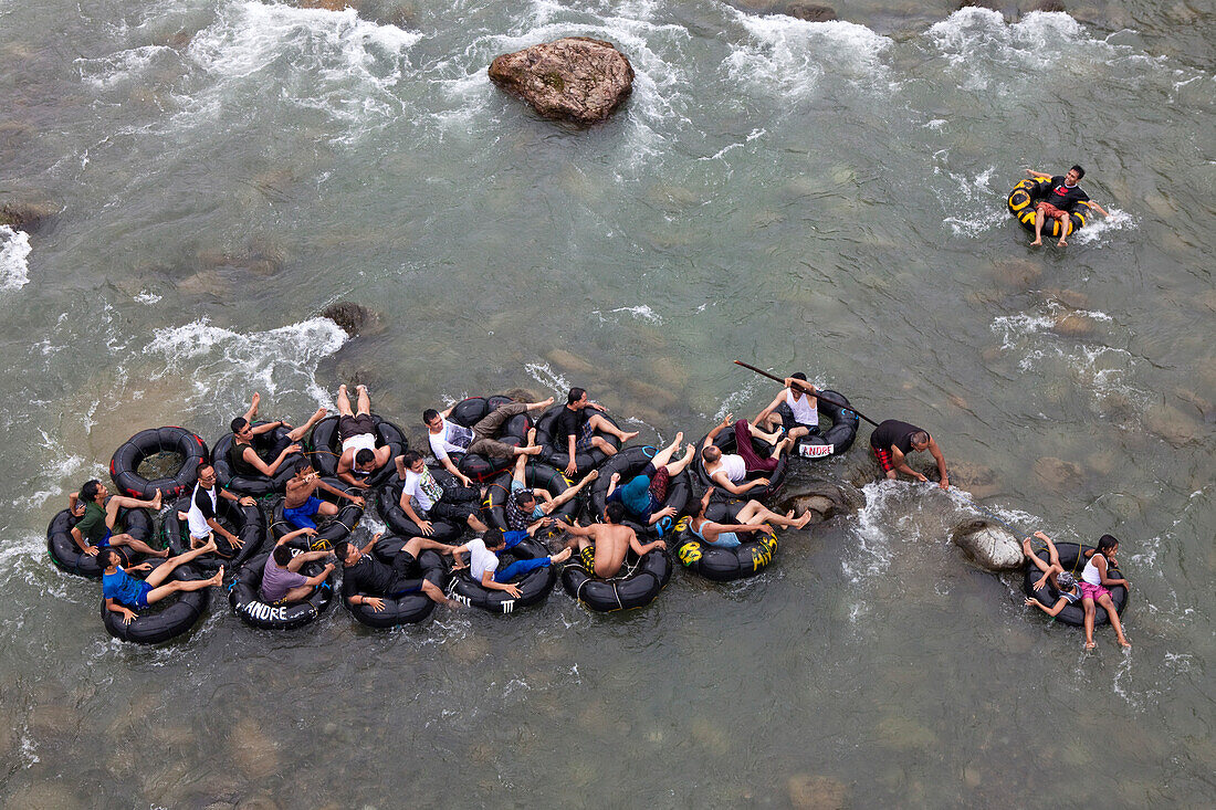 Indonesian tourists in Bukit Lawang tubing on the Bahorok river , Island of Sumatra, Indonesia, Southeast Asia